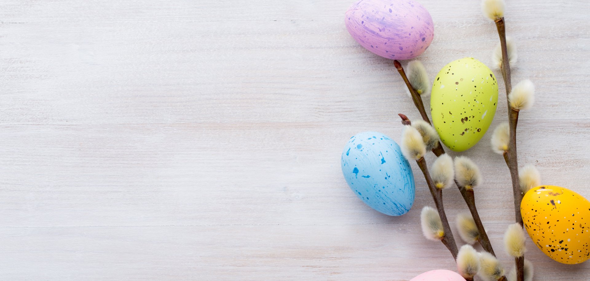 Symbolic Easter decoration with willow catkins and five eggs dyed in different colours.