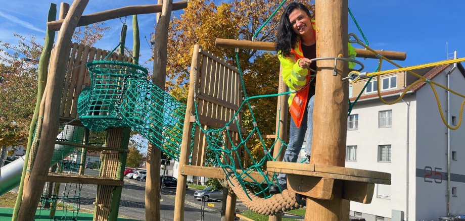Anna Golschmidt-Costa on a piece of playground equipment at the new playground in Marshall Heights