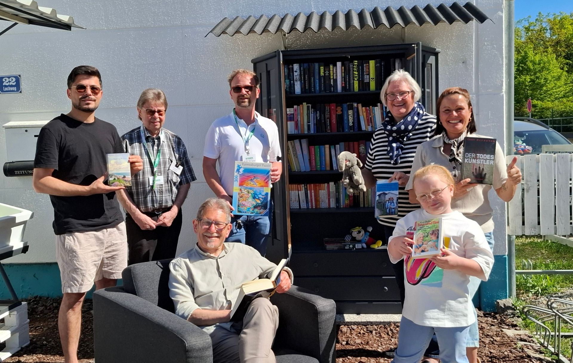 Mitarbeiter und Kunden der Aplawia vor dem neuen öffentlichen Bücherschrank