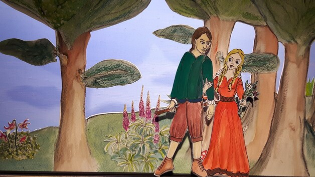 Die Papierfiguren Jorinde und Joringel vor einer Waldkulisse.