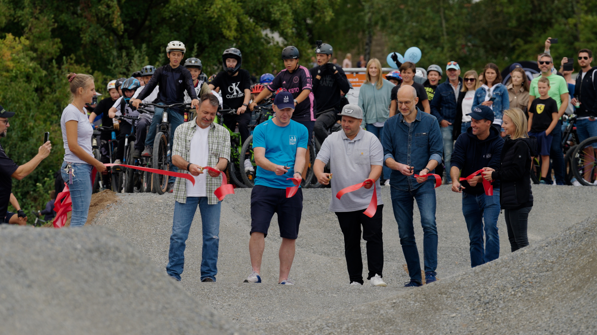 Durchschneiden des roten Bandes zur offiziellen Eröffnung des Kitzinger Bikeparks.