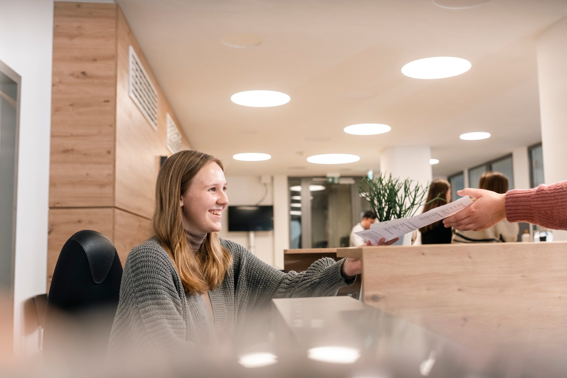 Employee hands a document to a citizen.
