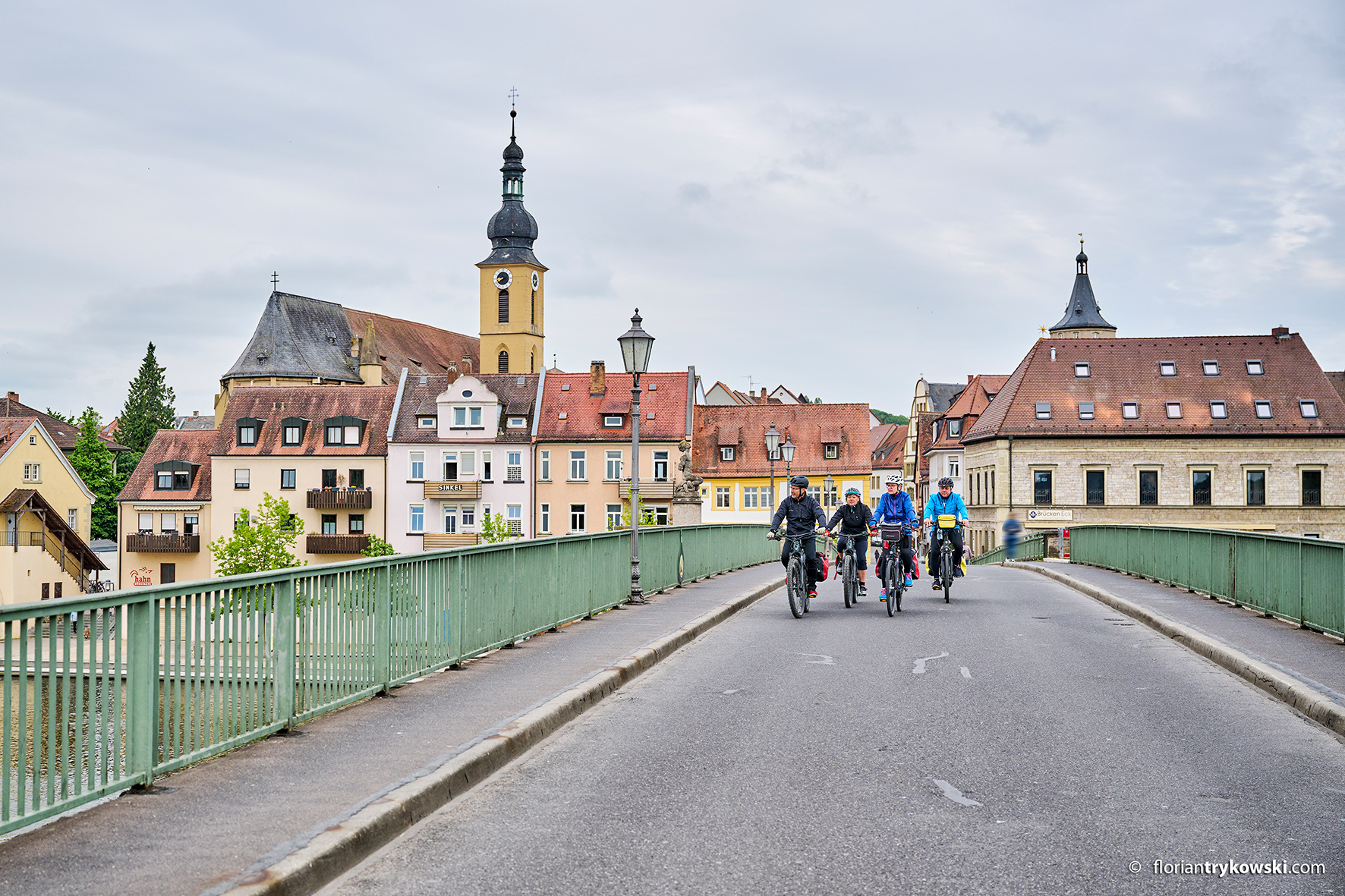 A group of cyclists crosses the old main bridge in Kitzingen