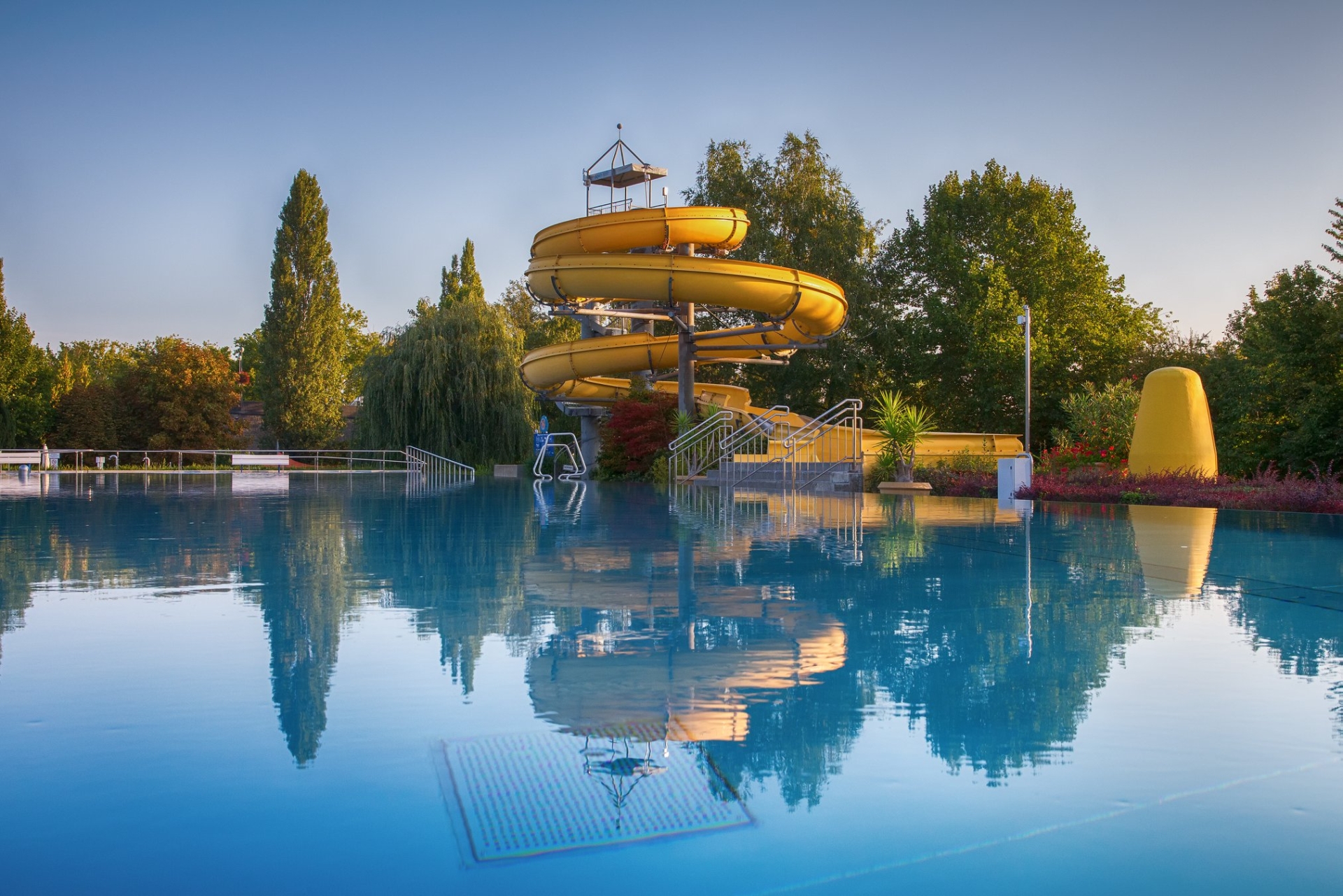 Outdoor pool Mondseeinsel View of the yellow water slide in the outdoor pool on Mondsee Island.