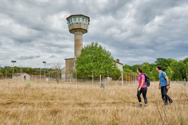 2 people are on the grounds of a Lostplace with a view of the watchtower