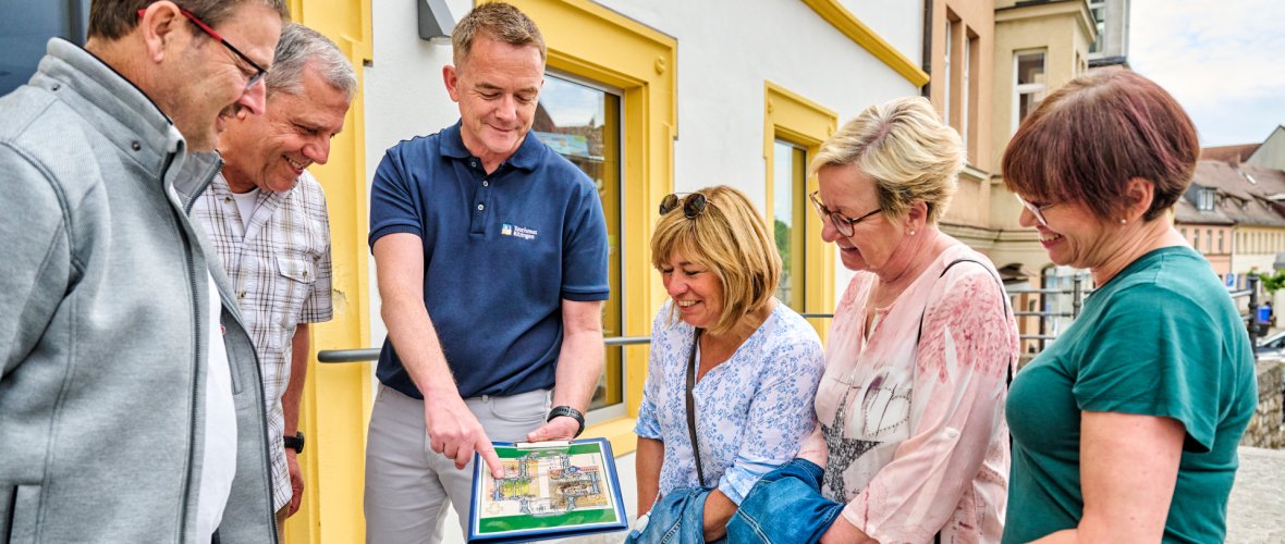 A man shows the group a picture and explains something about it