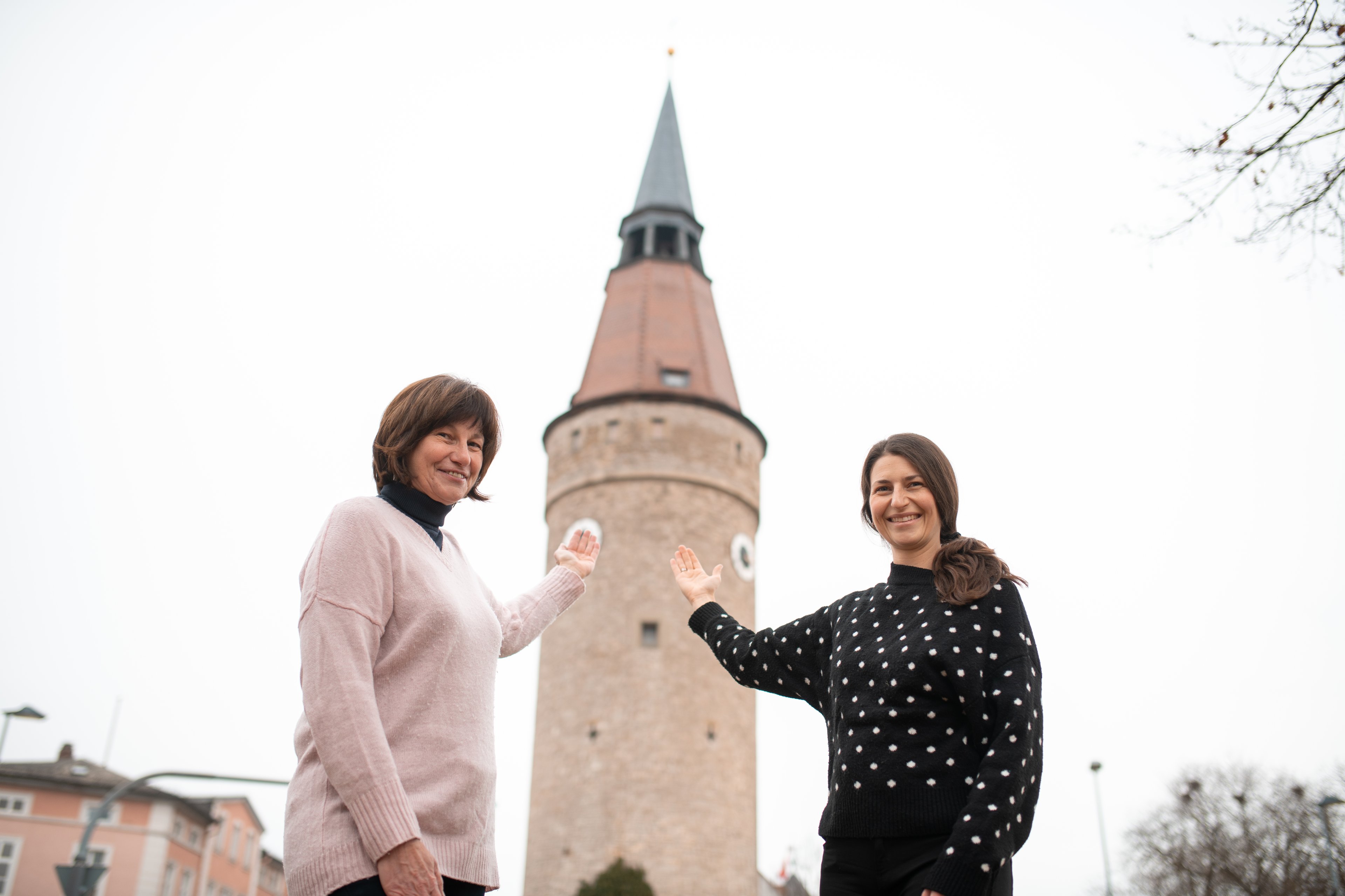 Two women stand in front of the Falterturm in Kitzingen