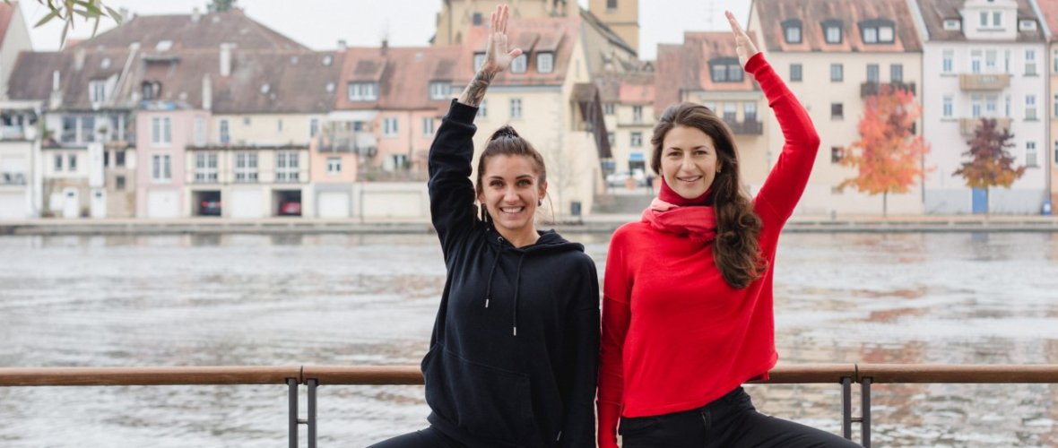 Two women do yoga on the Main
