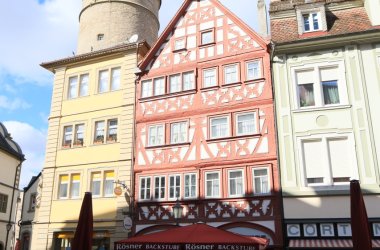 Blick auf drei Häuser am Marktplatz, in der Mitte das Poganietzhaus. Im Hintergrund der Marktturm