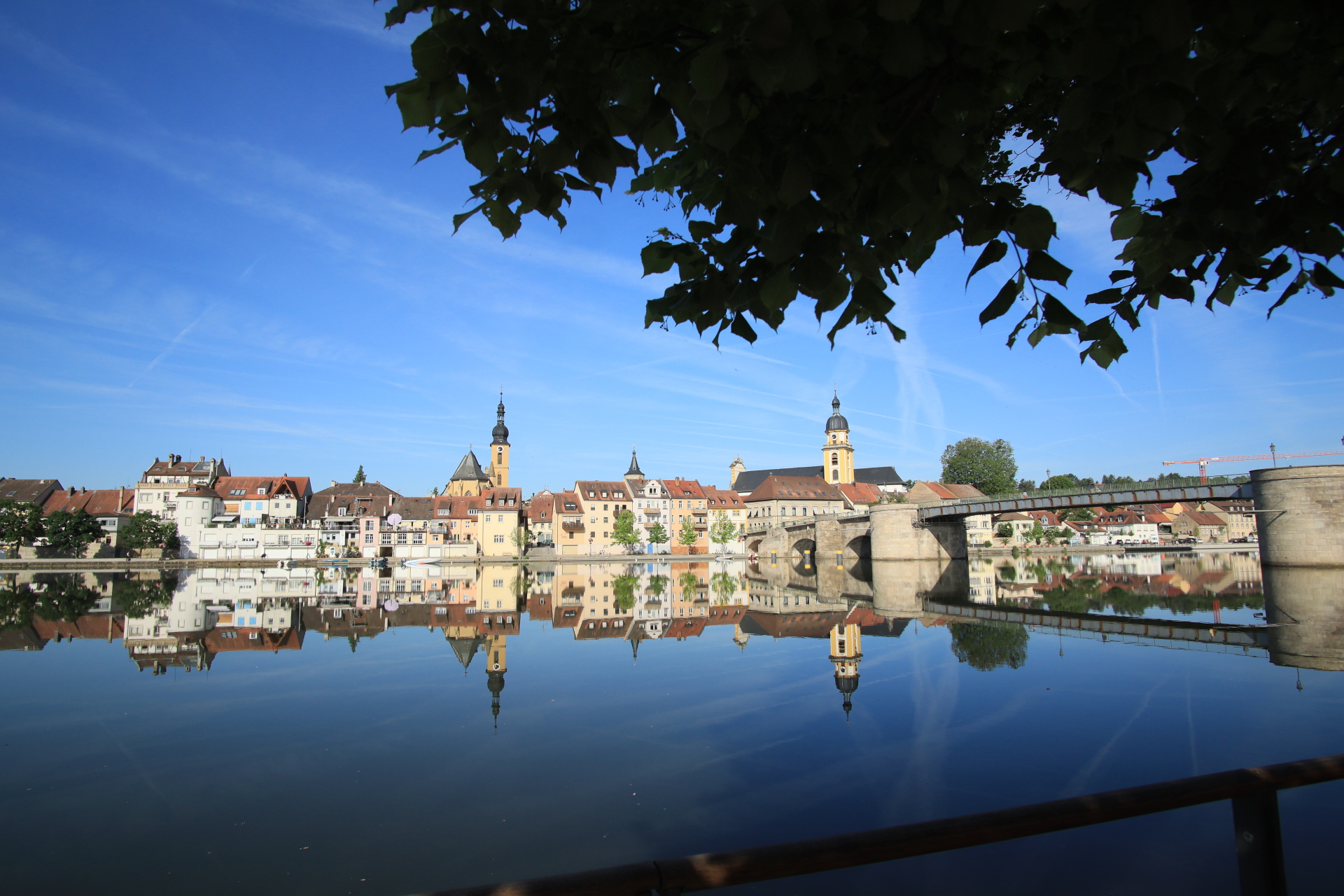 View of Kitzingen from the town balcony in summer, with the Alte Mainblicke on the right. The silhouette of the town is reflected in the Main