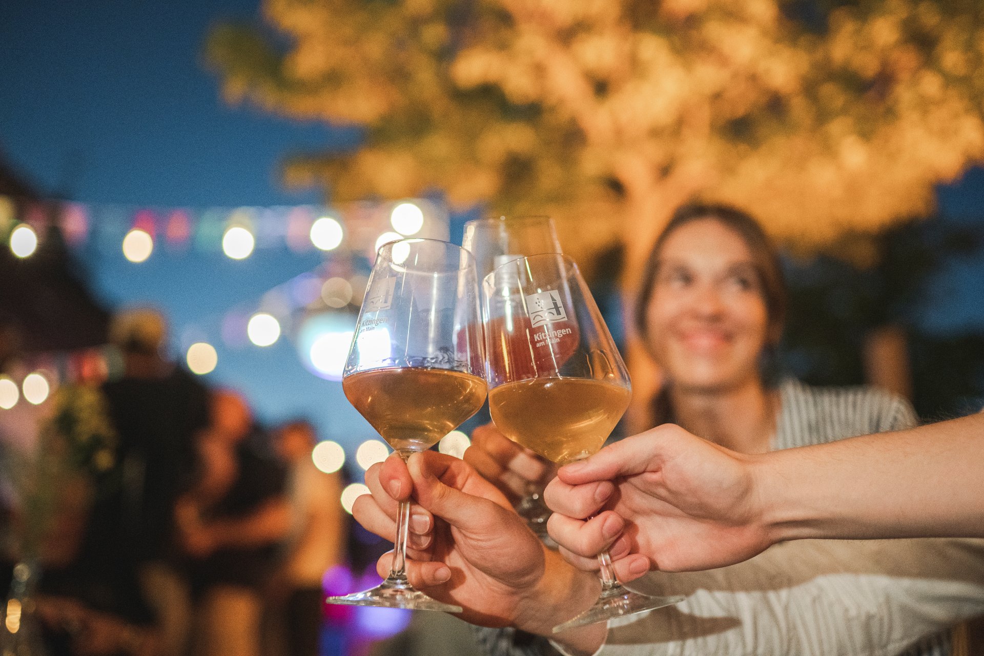 Several people clink glasses of wine.