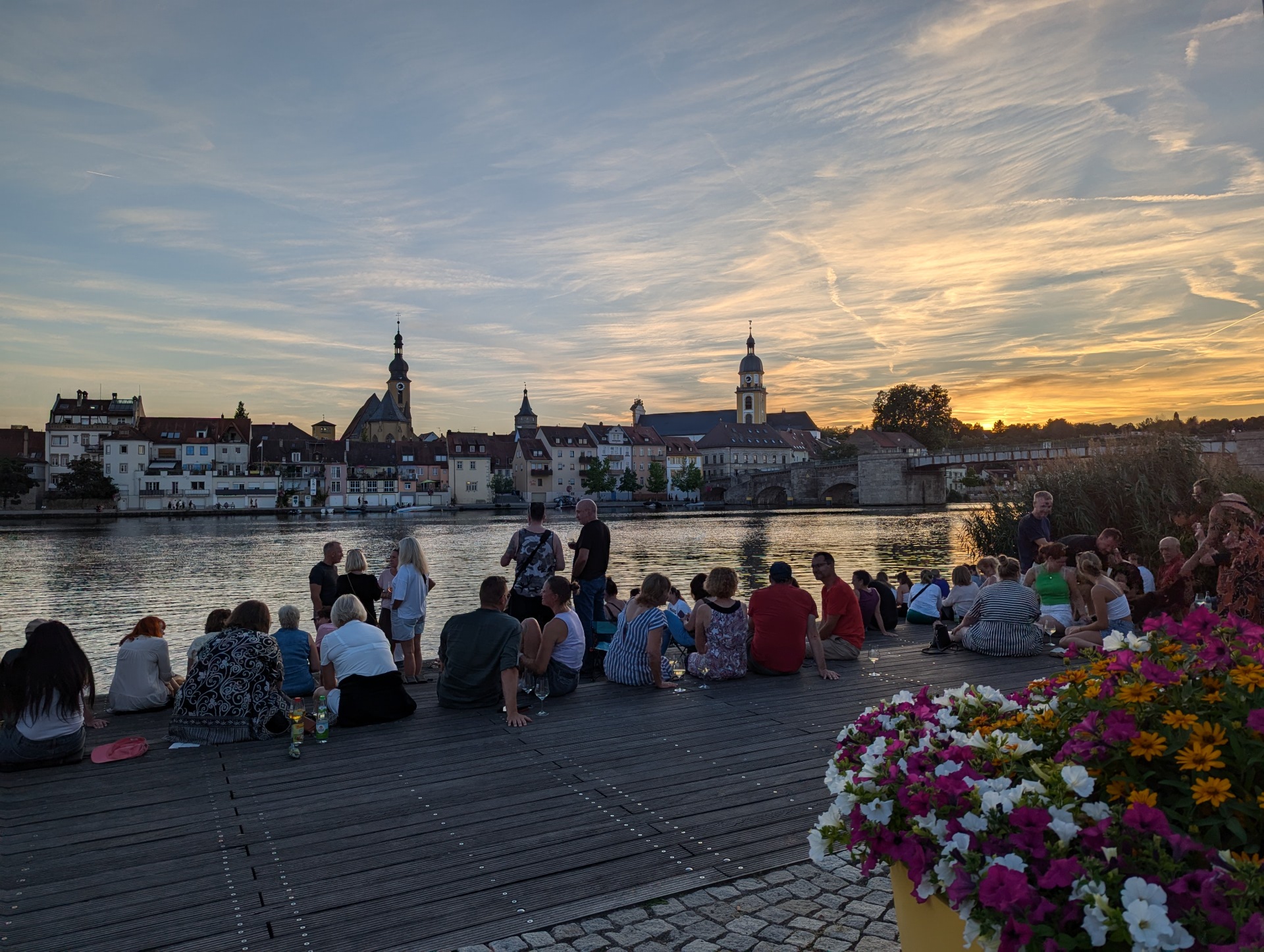 People on a city balcony one evening, with the city skyline in the background