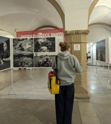 A woman stands in front of a picture