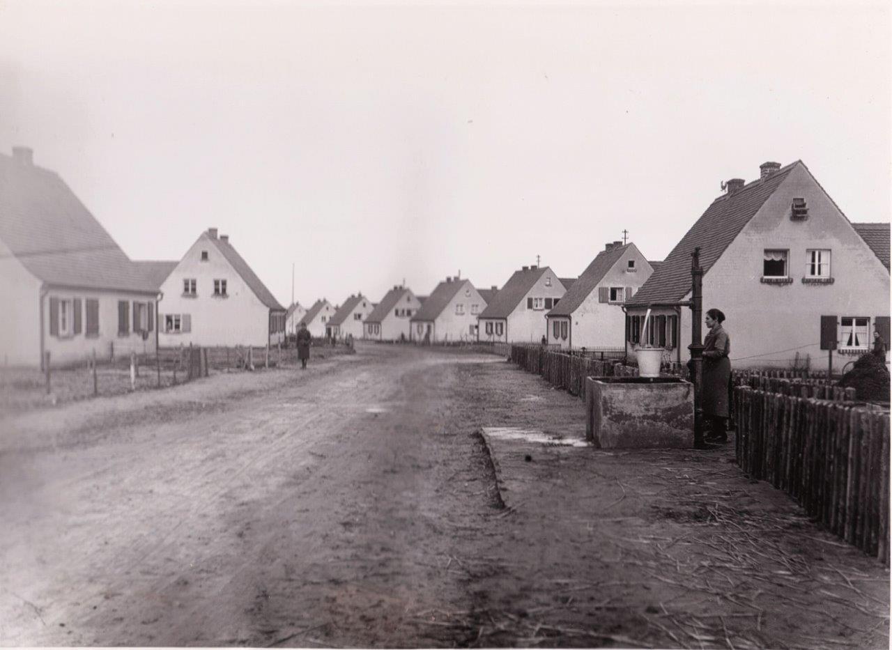 Anselm Caliz war der erste Siedler in der Kitzinger Siedlung. Der größte Stadtteil Kitzingens ist über 100 Jahre alt. Am Haus von Anselm Caliz, im Texasweg 3, ist eine Gedenktafel angebracht.