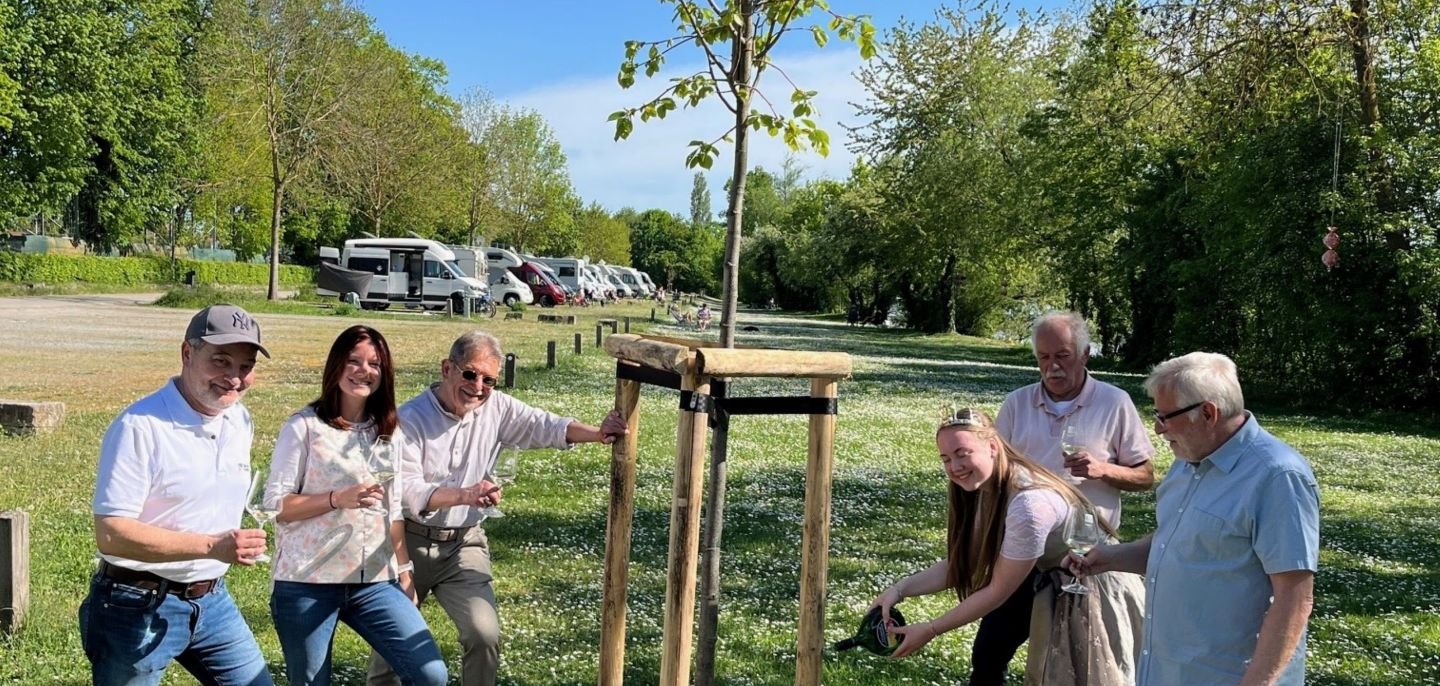 Der neue Baum auf dem Wohnmobilstellplatz wird von Gärtnerkönigin Annika Maurer ordnungsgemäß mit Wein angegossen. Die Tradition beobachten Gästeführer Detlef Hildebrand, TI-Leiterin Christina Richard, Tourismus-Referent Walter Vierrether, Stellplatz-Kontrolleur Dieter Franz und zweiter Bürgermeister Manfred Freitag.