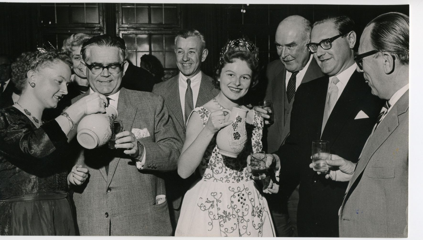 Gesucht: Historische Weinfestbilder Historische Aufnahmen, wie dieses Bild aus dem Jahr 1958, sucht die Stadt Kitzingen. Es zeigt die damalige deutsche Weinkönigin Karoline Hartmann mit OB Dr. Klemmert, Landrat Schad, US-General Lewis, Landrat Held, Landwirtschaftsrat Cornelsen sowie der Fränkischen Weinkönigin Rosemarie Schreck (links) beim Weinfestempfang