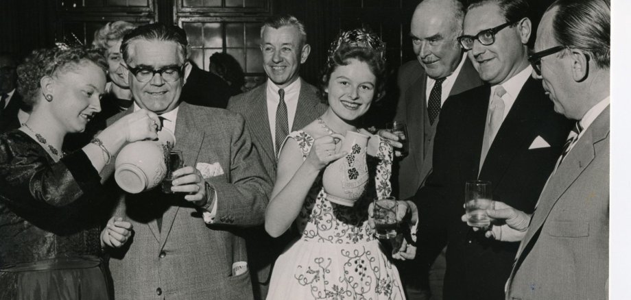 Gesucht: Historische Weinfestbilder Historische Aufnahmen, wie dieses Bild aus dem Jahr 1958, sucht die Stadt Kitzingen. Es zeigt die damalige deutsche Weinkönigin Karoline Hartmann mit OB Dr. Klemmert, Landrat Schad, US-General Lewis, Landrat Held, Landwirtschaftsrat Cornelsen sowie der Fränkischen Weinkönigin Rosemarie Schreck (links) beim Weinfestempfang