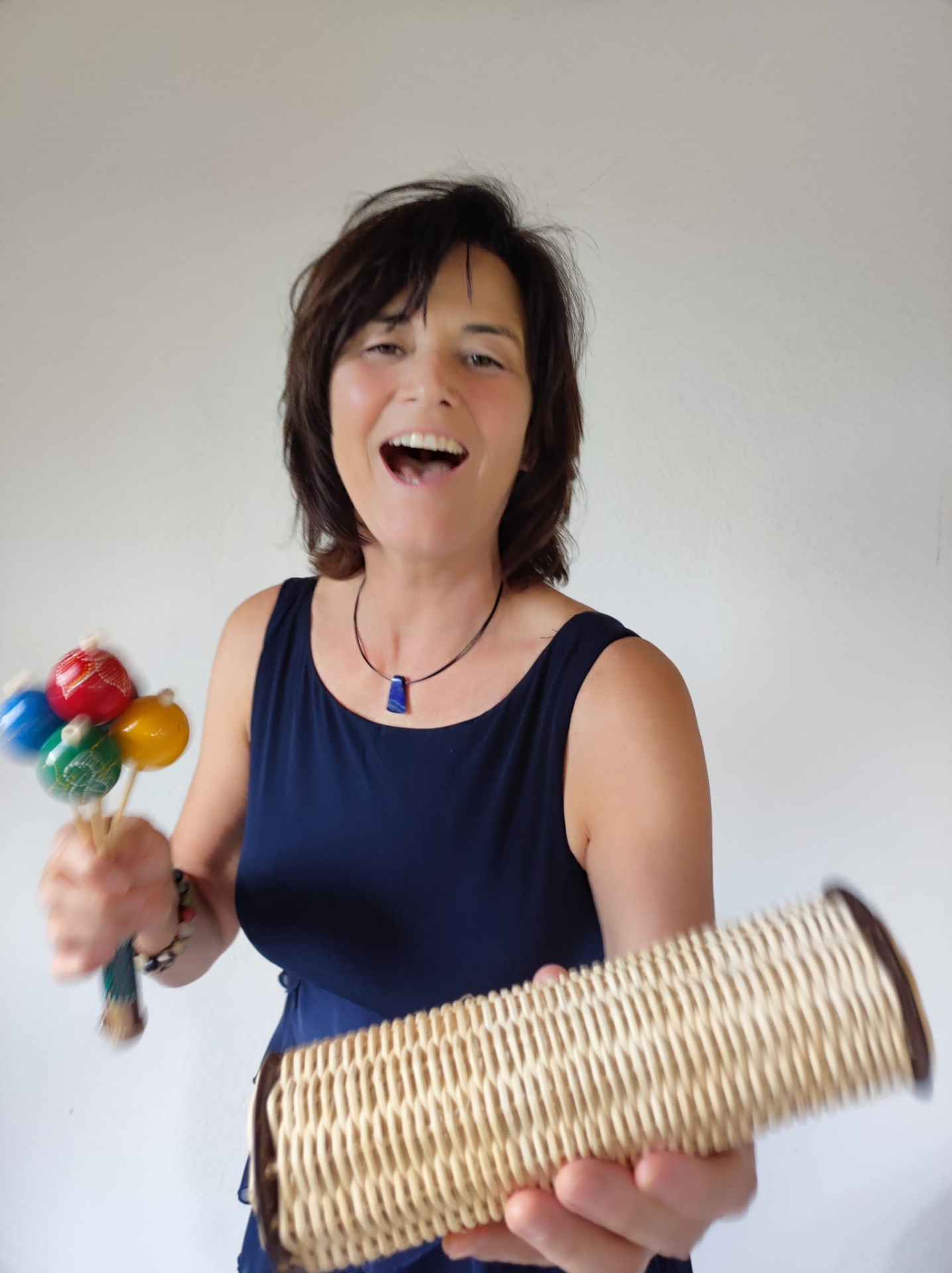 Bettina Winkler Kusleiterin Bettina Winkler hält eine Rassel und ein Xylophon in der Hand.