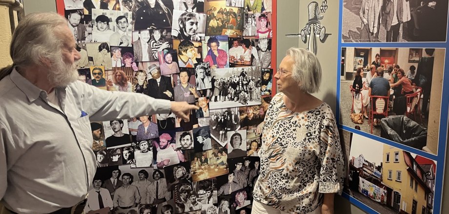 PAM-Ausstellung Klaus Christof und Renate Haass stehen vor einer ihrer Lieblings-Stellwände in der Ausstellung: Eine Foto-Collage von Besuchern des ehemaligen Marktcafés.