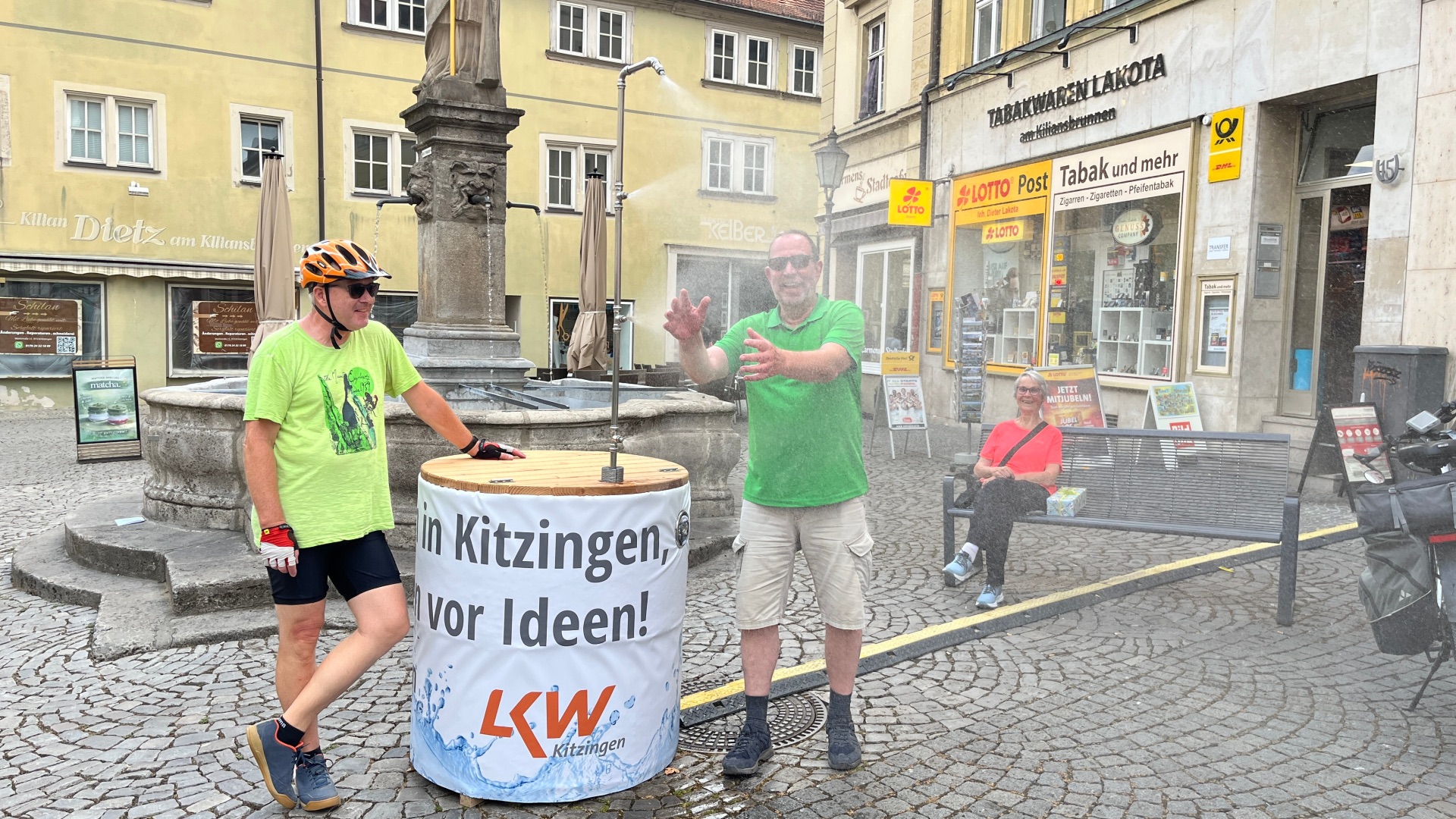 Willkommene Abkühlung Eine Menge Spaß und gute Laune macht die neue Nebeldusche am Kitzinger Marktplatz. Diese Radtouristen aus dem Sauerland waren die ersten, die die willkommene Abkühlung testeten.