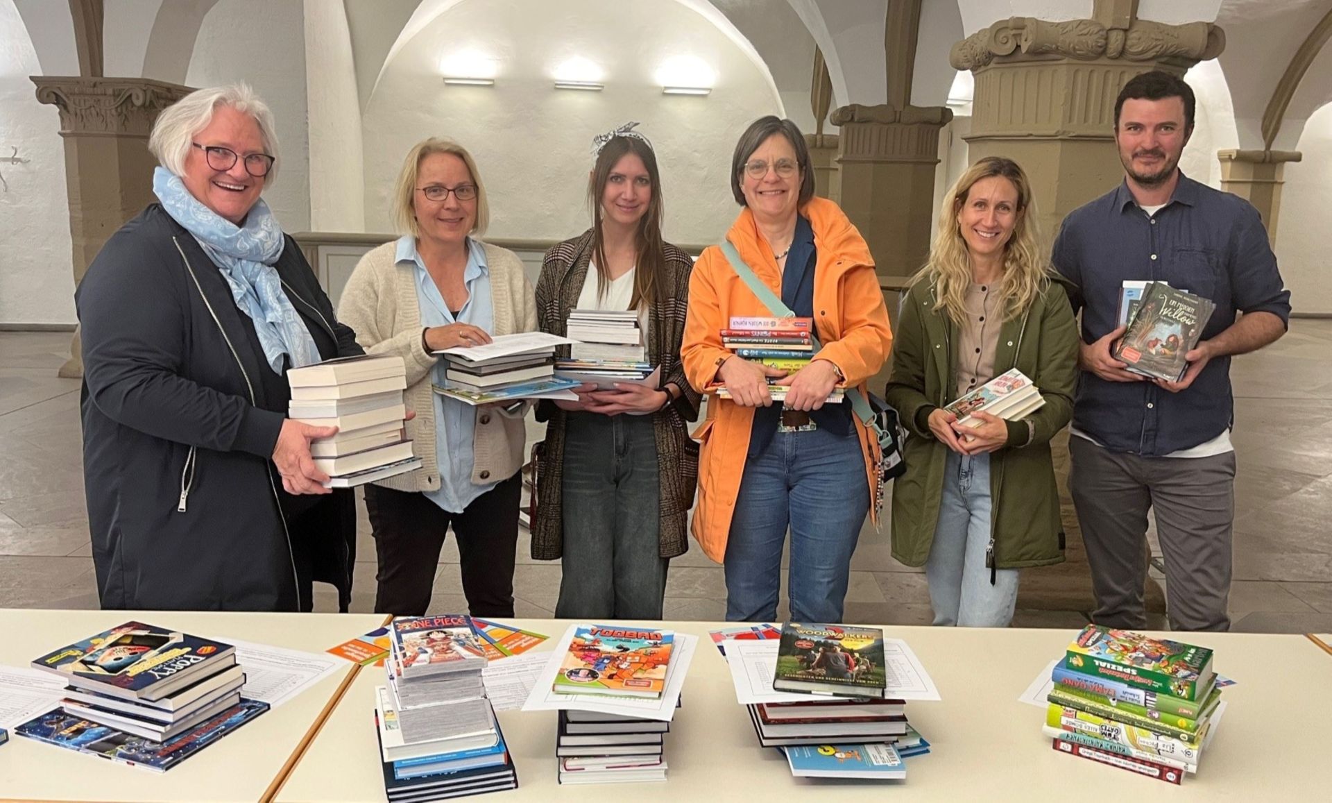 Astrid Glos, Petra Krauß-Broschart und Theresa Schmelz von der Erich-Kästner-Schule, Carola Schmidt von der Grundschule Siedlung, Sabine Laschinski-Mitnacht und Andreas Schirm von der Grundschule St. Hedwig holen die gespendeten Bücher in der Rathaushalle ab.
