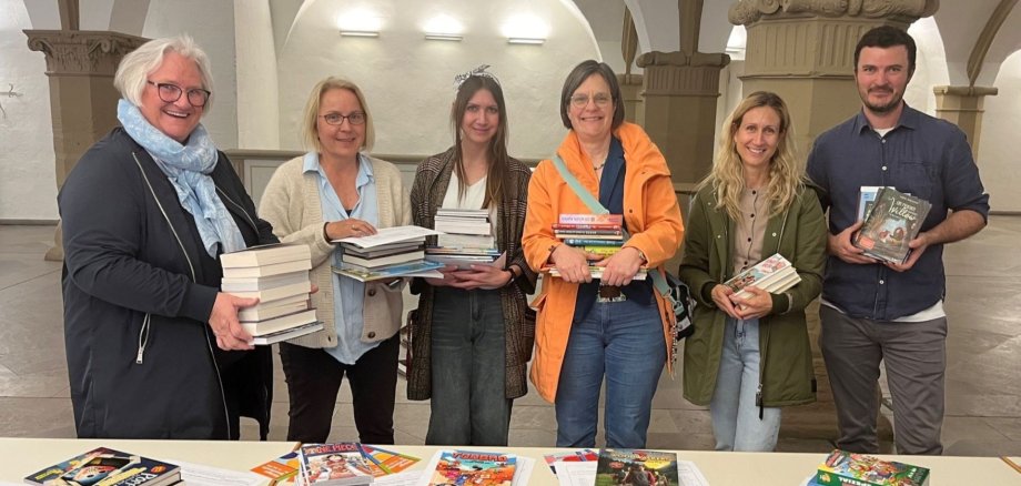 Astrid Glos, Petra Krauß-Broschart und Theresa Schmelz von der Erich-Kästner-Schule, Carola Schmidt von der Grundschule Siedlung, Sabine Laschinski-Mitnacht und Andreas Schirm von der Grundschule St. Hedwig holen die gespendeten Bücher in der Rathaushalle ab.