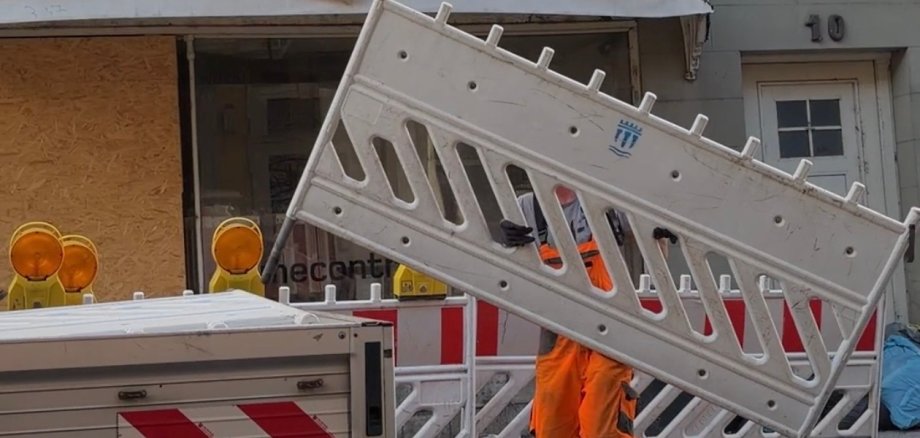 Abbau Sperrung Ein Bauhofmitarbeiter trägt eine Straßensperrung.