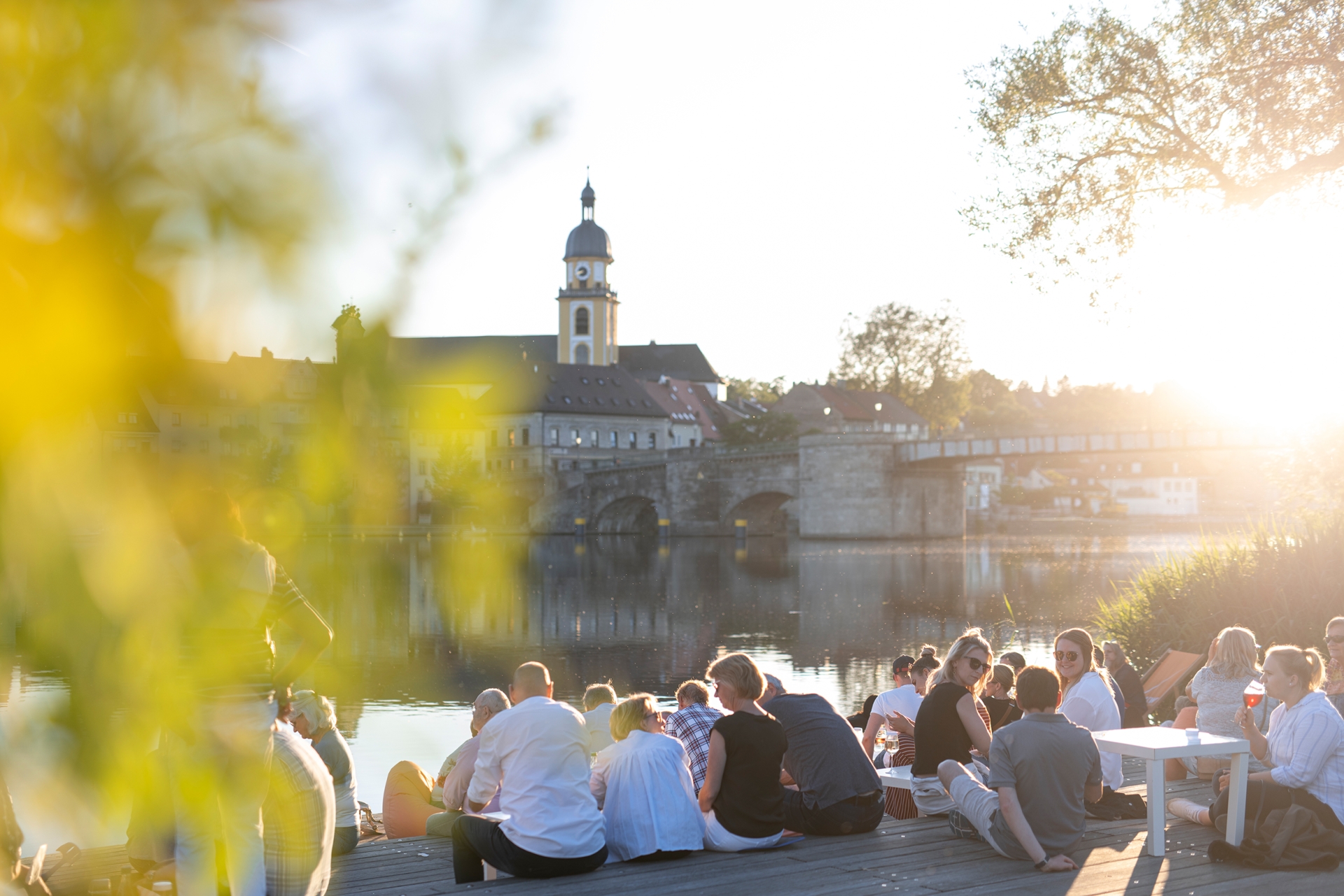 Menschen beim Stadtschoppen am Stadtbalkon am Abend