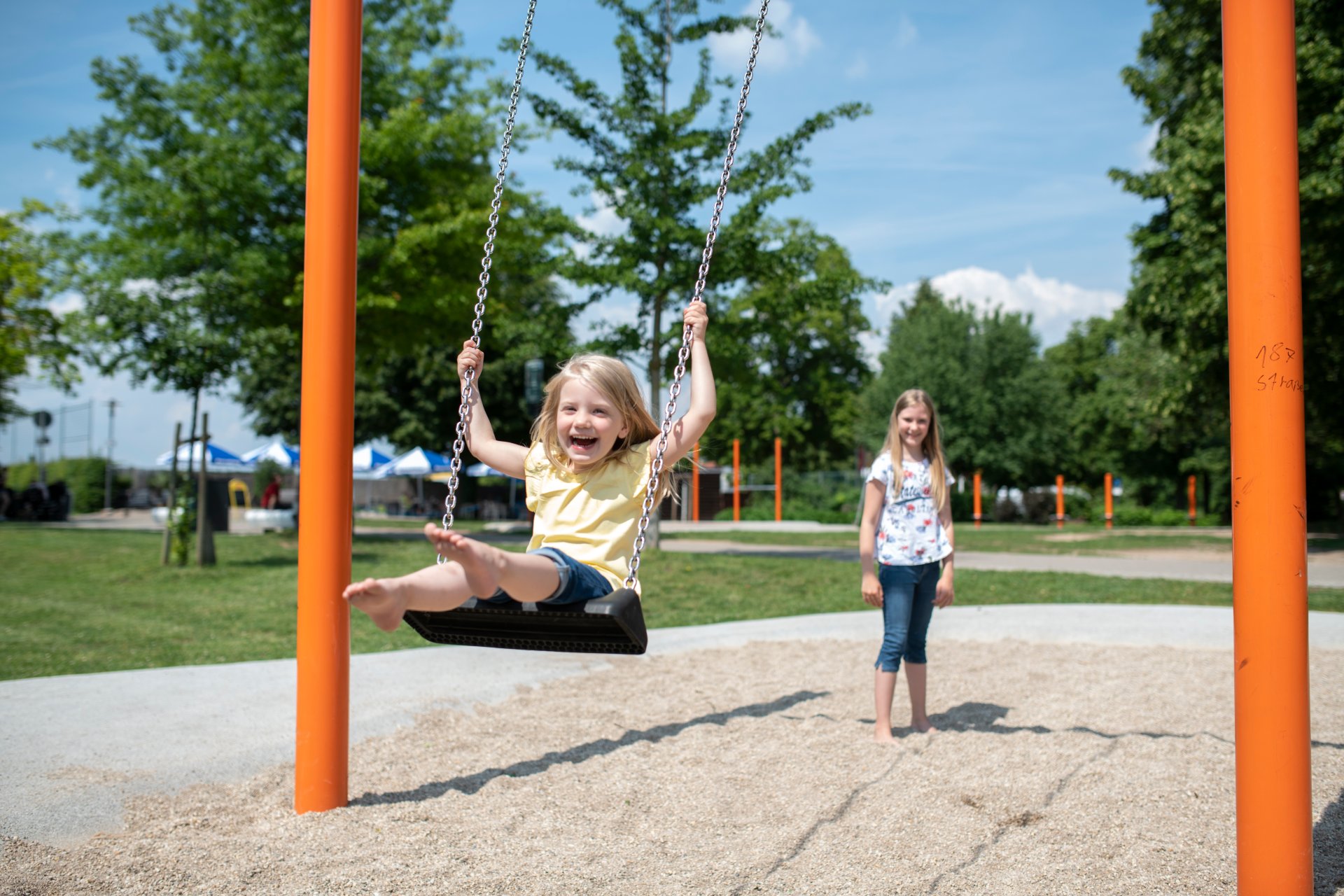 Ein Kind schaukelt am Spielplatz am Bleichwasen.