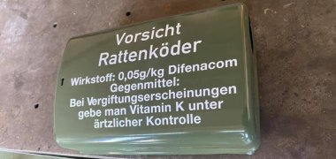 Eine grüne Rattenköderbox auf einem Tisch.