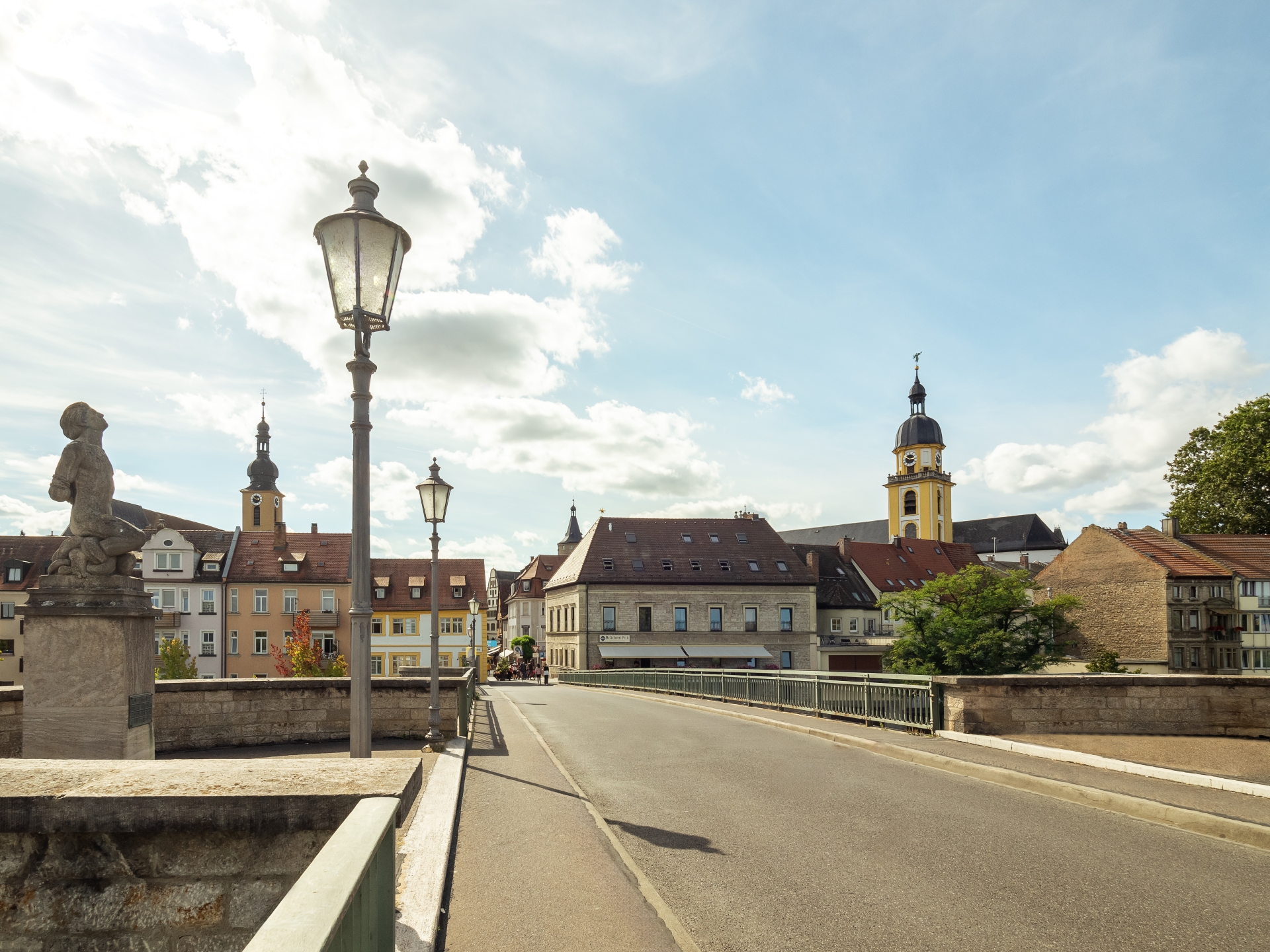 Blick auf die Kitzinger Innenstadt von der Alten Mainbrücke. Links steht die Richard Rother Figur.