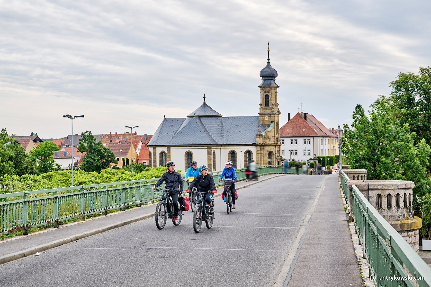 Gruppe von 4 Personen fährt mit dem Fahrrad über die alte Mainbrücke.