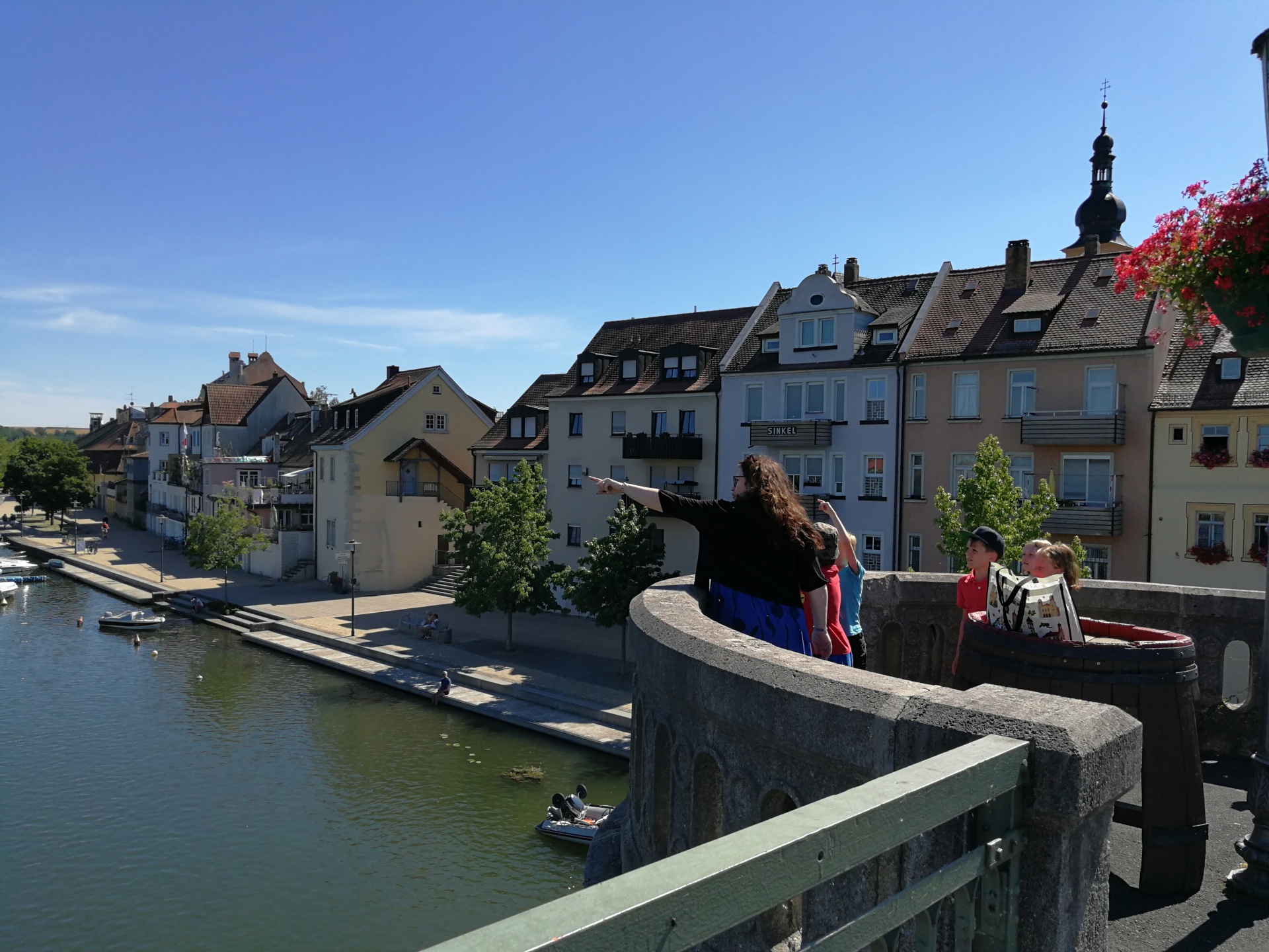 Kinderstadtführung Eine Gästeführerin erklärt Kindern etwas auf der alten Mainbrücke