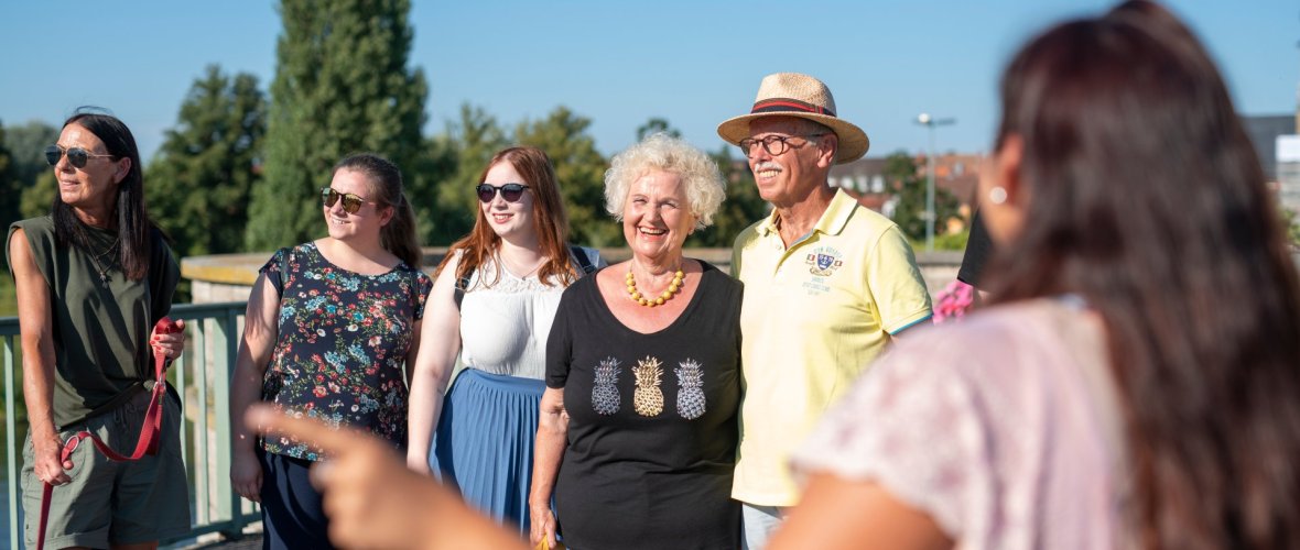 Eine Gästeführerin ist mit ihrer Gruppe auf der alten Mainbrücke