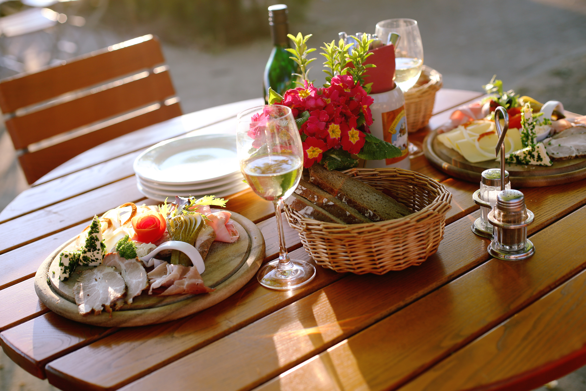 Tisch angerichtet mit Wurstplatte, Brot und Wein