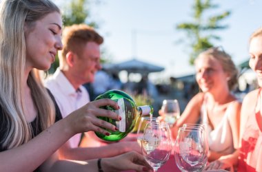 Menschen trinken Wein auf dem Kitzinger Promenadenweinfest