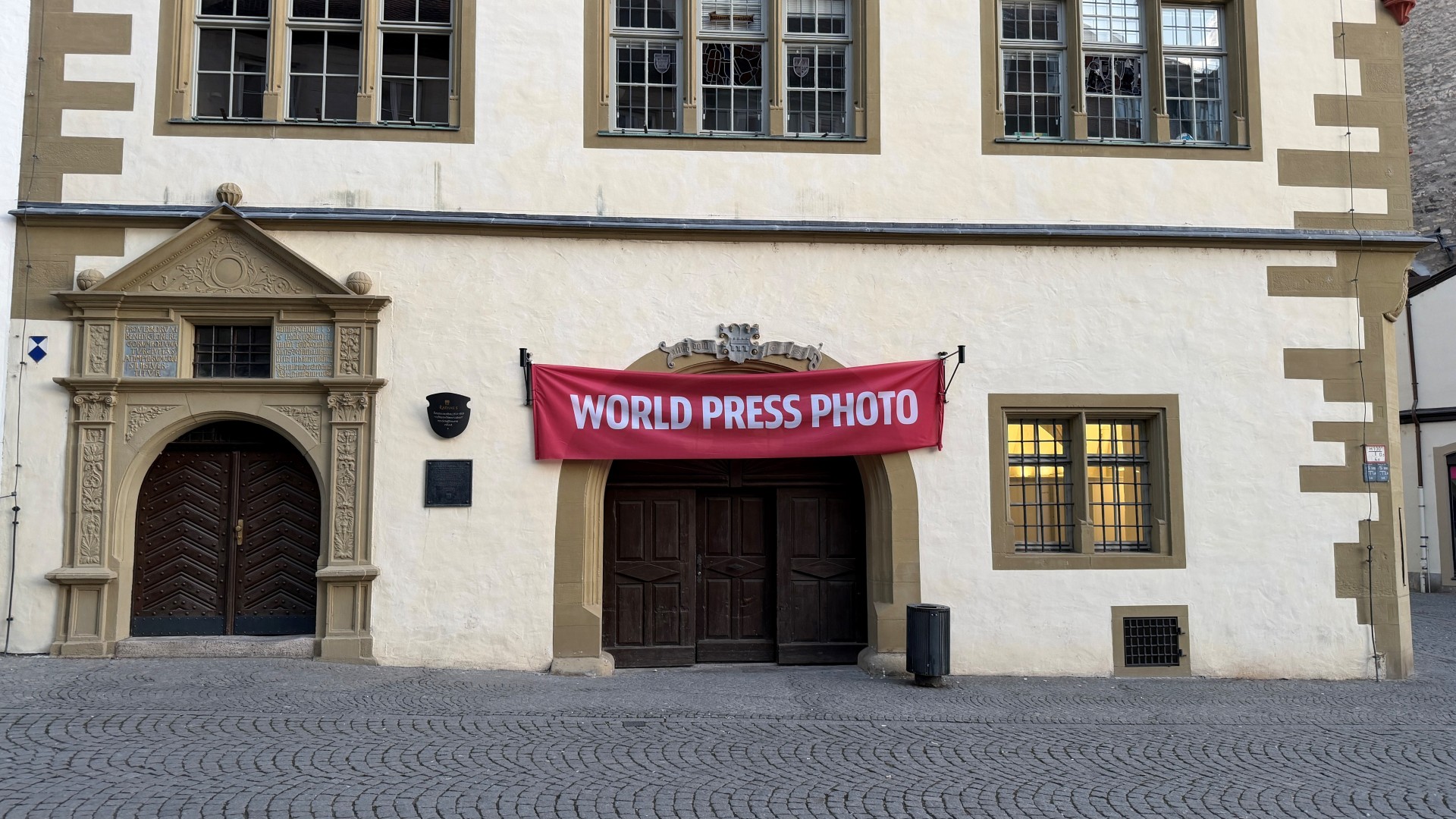 Roter World Press Photo Banner über der Eingangstür der Rathaushalle.